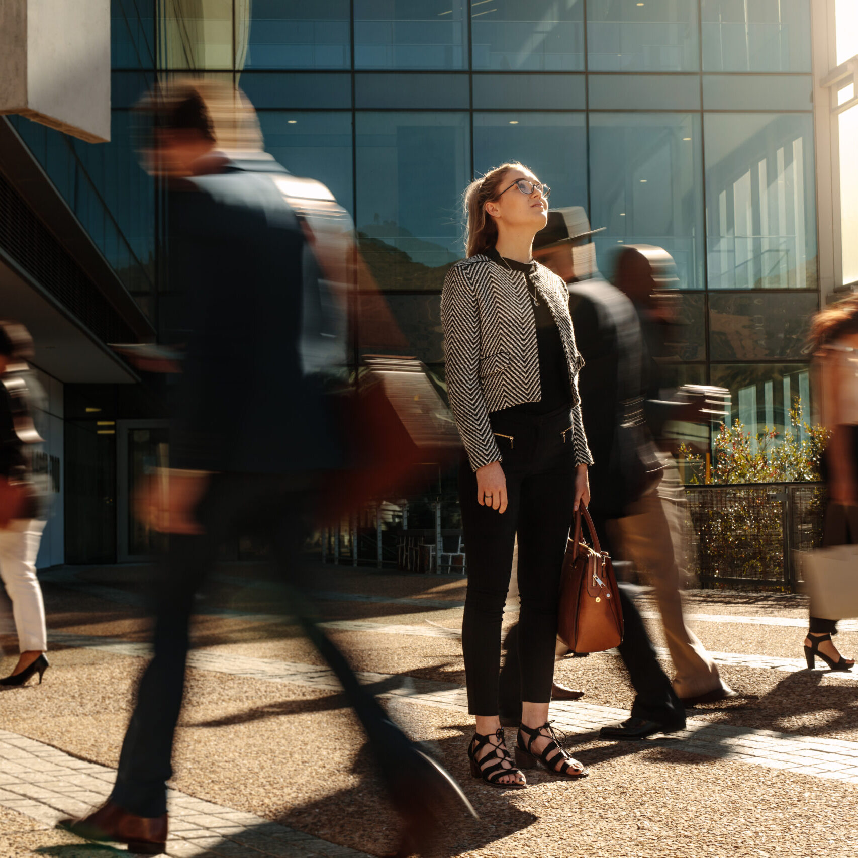 Woman,Standing,Amidst,A,Busy,Office,Going,Crowd,Hooked,To shutterstock 1783490738 2
